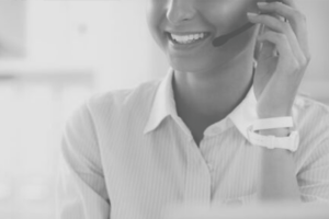 Customer service representative wearing a headset and smiling while on a call in a bright office