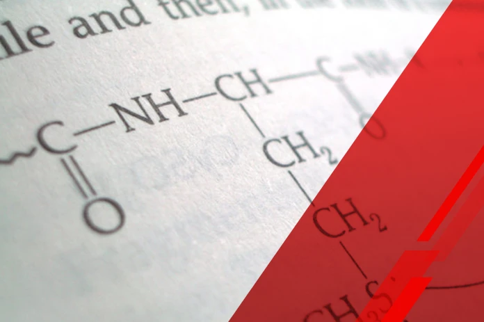 Close-up of a chemistry page showing a molecular structure diagram (NH-CH-... with CH2 groups) partially covered by a red diagonal overlay.
